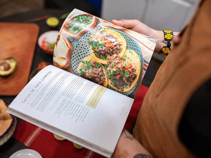 Person holding open recipe book.