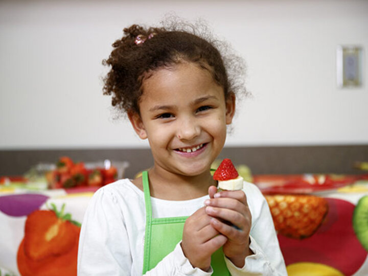 Child holding up some food.