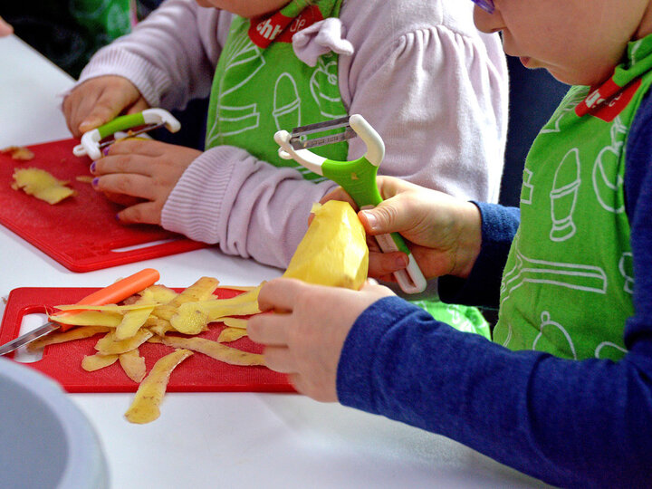 Children peeling potatoes.